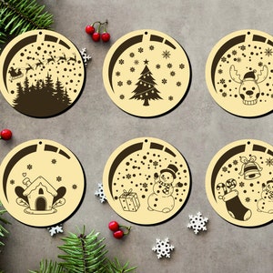 Könnte beinhalten: Sechs runde Holzornamente mit verschiedenen Weihnachtsmotiven. Die Ornamente sind beige mit braunen Motiven. Die Motive umfassen einen Schneemann, einen Weihnachtsbaum, ein Rentier, ein Haus, einen Strumpf und den Weihnachtsmann, der in einem Schlitten fliegt.
