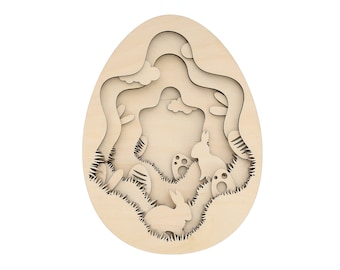 May include: Wooden Easter egg ornament with a cutout design of a forest scene with two rabbits, clouds, and eggs. The ornament is made of light brown wood.