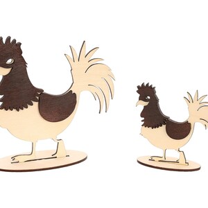 Peut inclure: Deux figurines de coq en bois, l'une plus grande que l'autre. Les deux coqs sont brun et blanc avec une tête et des plumes de queue brunes. Les coqs sont debout sur une base en bois.