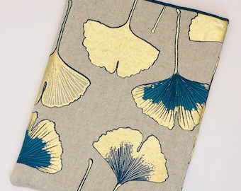 Könnte beinhalten: Eine graue Clutch aus Leinen mit einem Muster aus goldenen und türkisfarbenen Ginkgoblättern.