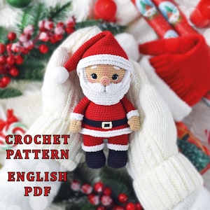 May include: A crocheted Santa Claus doll with a red suit, hat, and black boots. The doll has a white beard and a black belt with a silver buckle. The text "CROCHET PATTERN ENGLISH PDF" is displayed in the image.