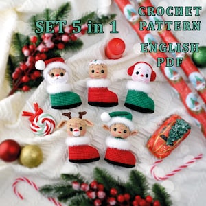Può includere: Un set di cinque ornamenti natalizi all'uncinetto, tra cui Babbo Natale, un omino di pan di zenzero, un pupazzo di neve, una renna e un elfo. Ogni ornamento ha la forma di uno stivale con finiture bianche. Il testo dice "SET 5 in 1" e "CROCHET PATTERN ENGLISH PDF".