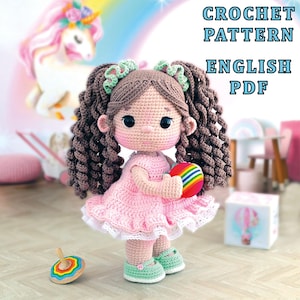 May include: A handmade crochet doll with brown curly hair, wearing a pink dress and green shoes, holding a colorful ball. The doll has large black eyes and is standing near a wooden spinning top. The image includes the text "CROCHET PATTERN ENGLISH PDF".