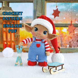 Könnte beinhalten: Häkelanleitung für eine Weihnachts-Elfenpuppe mit einem rot-weiß gestreiften Shirt, blauen Latzhosen und einer roten Weihnachtsmütze. Der Elf hält ein Paar blaue Skier in der Hand. Die Anleitung ist in englischer Sprache und als PDF-Download verfügbar. CROCHET PATTERN ENGLISH PDF