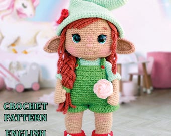 May include: Crochet pattern for a green elf doll with red hair, a green hat, and a pink flower. The pattern is available in English and is a PDF download.
