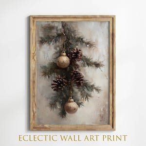 May include: A framed print of a painting depicting a sprig of pine branches with brown pine cones and gold baubles hanging from the branches. The background is a muted beige with a textured look.