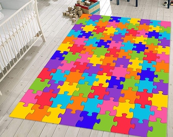 Pode incluir: Um tapete colorido com padrão de peças de quebra-cabeça em tons de vermelho, laranja, amarelo, verde, azul, roxo e rosa. O tapete é feito de um material macio e durável e é perfeito para adicionar um toque divertido a qualquer cômodo.