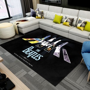 May include: Black and white rug with a graphic of The Beatles walking across a street, with the band members' names and the year 1969 printed below.