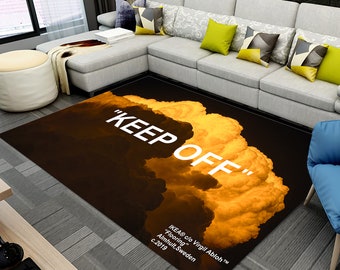 May include: A black and yellow rug with a white "KEEP OFF" text and a cloud design. The rug is made by IKEA in collaboration with Virgil Abloh.