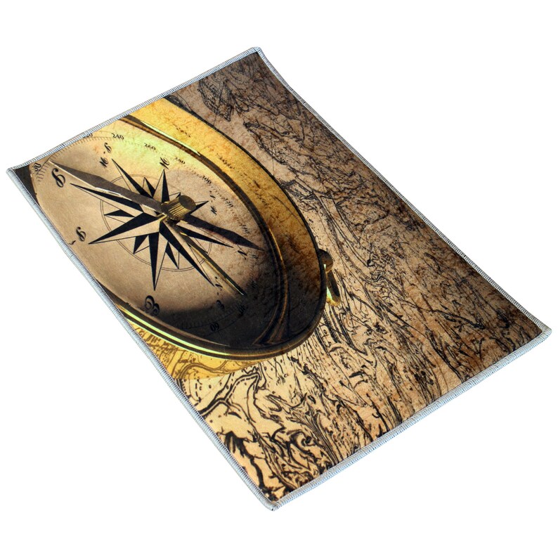 May include: A rectangular, nautical-themed rug featuring a vintage compass and a detailed map design. The compass is gold-toned with a black directional arrow, set against a sepia-toned background. The rug has a light blue border.