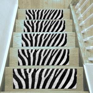 May include: Five black and white zebra print stair treads. The treads are made of a soft, plush material and are designed to add a touch of style and safety to any staircase.