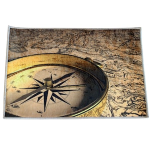 May include: A rectangular rug featuring a vintage compass with a gold-colored bezel and a black and white compass rose. The compass is set against a backdrop of an antique map in shades of brown and beige.