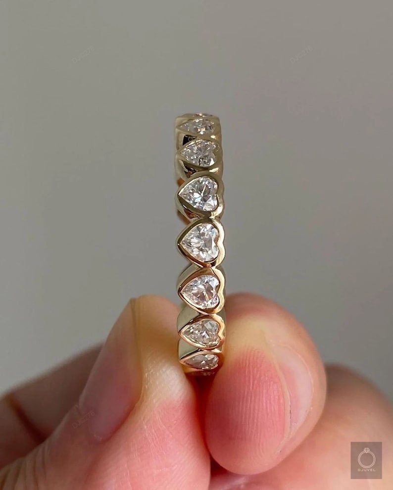 K&ouml;nnte beinhalten: Ein Goldring mit einer Reihe herzf&ouml;rmiger Diamanten.