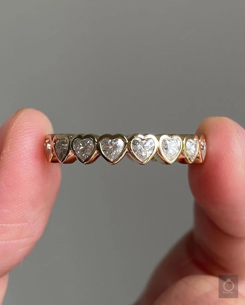 K&ouml;nnte beinhalten: Ein Goldring mit einer Reihe herzf&ouml;rmiger Diamanten.
