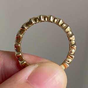 K&ouml;nnte beinhalten: Ein Goldring mit einem strukturierten Design und kleinen Diamanten, die in die Band gefasst sind.