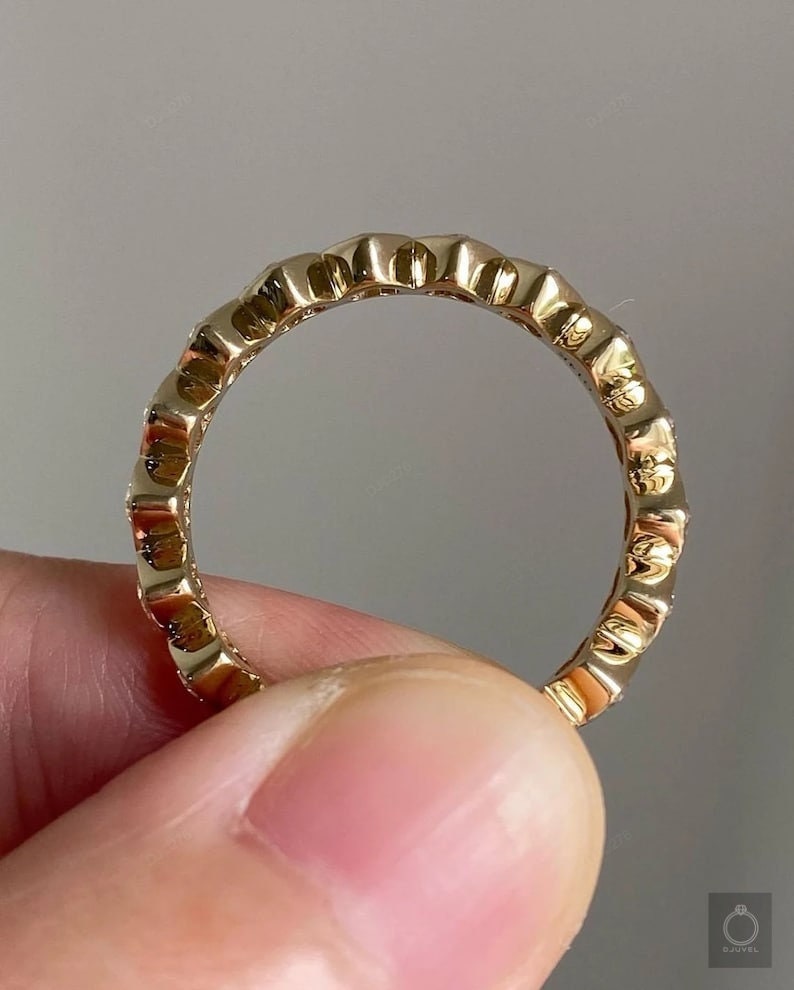 K&ouml;nnte beinhalten: Ein Goldring mit einem strukturierten Design und kleinen Diamanten, die in die Band gefasst sind.