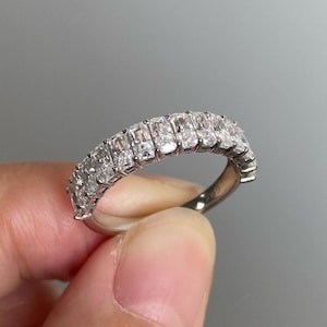 May include: A silver band ring with a row of rectangular-shaped diamonds set in a pave setting.