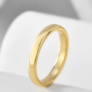May include: A simple gold wedding band with a smooth, polished finish.
