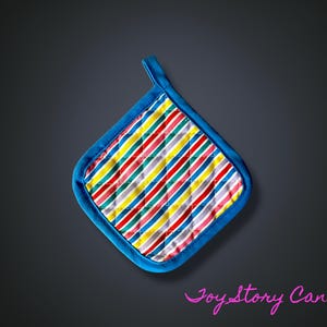 Op de afbeelding: Een kleurrijke, gewatteerde pannenlap met een blauwe rand en ophanglus. De pannenlap heeft diagonale strepen in rood, geel, blauw en grijs. Een keukenaccessoire.