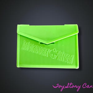 May include: A bright green envelope with the words "Monster High" embossed on the front.