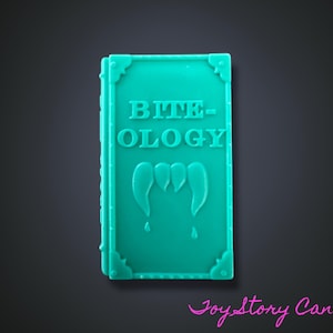 May include: A teal book with the word "BITE-OLOGY" embossed on the cover, featuring a graphic of three fangs. The book has decorative corner accents and a spine. The image is set against a dark background.