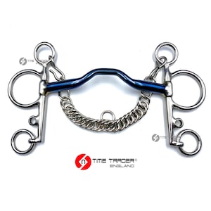 May include: A stainless steel horse bit with a curved, dark blue mouthpiece. The bit features a chain curb strap and circular rings on each side. The brand name "TIME TRADER ENGLAND" is printed in black and red at the bottom.
