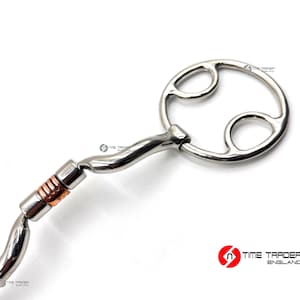 May include: A silver twisted snaffle bit with a copper roller and a double-jointed mouthpiece. The bit has a round, open ring on one end.