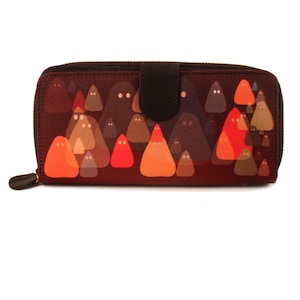 May include: A brown zippered wallet with a colourful print of orange, red and grey ghosts. The wallet has a brown leather flap.