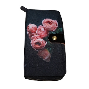 May include: A black zippered wallet with a floral print of pink roses on a dark background. The wallet has a black leather flap with a gold button.