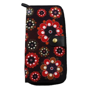 May include: A black zippered wallet with a red, white and brown geometric pattern. The wallet has a flap with a black leather strap and a gold button.