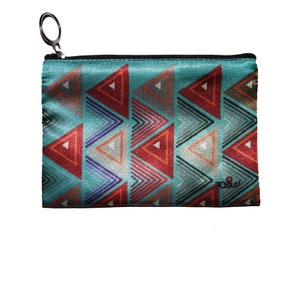 May include: A turquoise zippered pouch with a geometric pattern of red, orange, grey, and blue triangles. The pouch has a silver zipper pull.