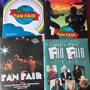 May include: Four vintage Country Music Fan Fair official programs. The covers feature text and graphics, including the event name, dates, and location in Nashville, Tennessee. The programs are from 1967, 1988, 1989, and 1992.