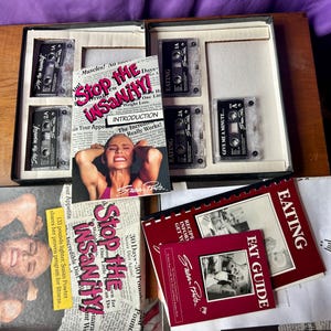 May include: A Stop the Insanity fitness program set by Susan Powter, including multiple audio cassette tapes, a Foundations of Wellness book, an Eating guide, and an introduction booklet, all featuring black, white, and red text and imagery.