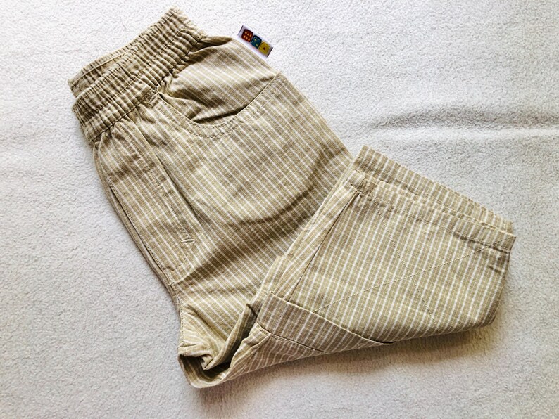 K&ouml;nnte beinhalten: Beigefarbene, gestreifte Shorts mit Kordelzugbund und einer kleinen Tasche vorne.