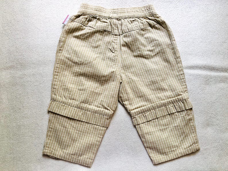 K&ouml;nnte beinhalten: Beige gestreifte Hose mit umgeschlagenem Saum. Die Hose hat einen Kordelzugbund und ist aus einem leichten Stoff gefertigt.