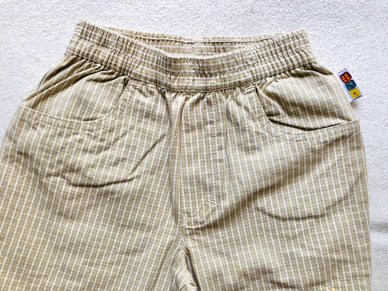 K&ouml;nnte beinhalten: Beige und wei&szlig;e karierte Shorts mit Bund und zwei Taschen.