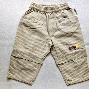 K&ouml;nnte beinhalten: Beigefarbene, gestreifte Shorts mit einem braunen Patch, auf dem "For the love of 300 miles" steht.