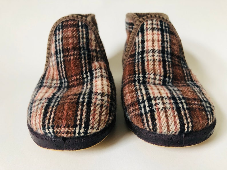 May include: A pair of brown and white plaid slippers with a dark brown sole.