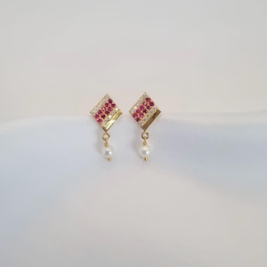 May include: Gold earrings with a square design featuring pink and clear rhinestones and a dangling pearl.