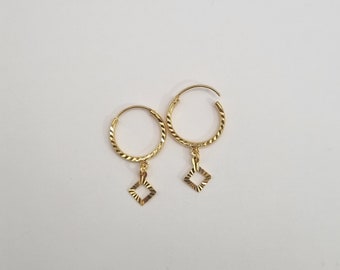 May include: A pair of gold hoop earrings with a small square charm hanging from each hoop.