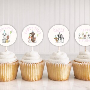 May include: Four cupcakes with white frosting and dog-themed cupcake toppers. The toppers feature illustrations of dogs wearing party hats and holding balloons. The text on the toppers reads "Happy Birthday", "Party Time", "Happy 10th Birthday", and "Happy Birthday".