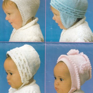 May include: Four knitted baby hats in white, blue, white, and pink. Each hat has ear flaps and a pom-pom on top. The hats are designed for babies from birth to 9 months.