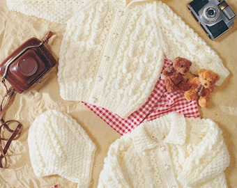 May include: Two white crocheted baby sweaters with button closures. One sweater has a hood and the other has a collar. Both sweaters have a textured, bobbly design.