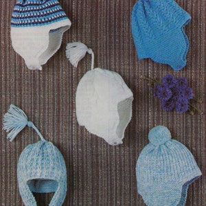 May include: Four knitted baby hats in blue and white with ear flaps and pom-poms. The hats are made with a variety of stitches and patterns.