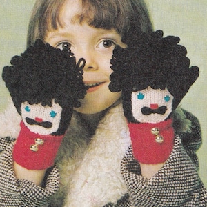 May include: A child wearing a black and white checkered coat with a white fur collar is wearing a pair of red and black knit mittens with a cartoon face on each. The mittens have black hair, blue eyes, a red nose, a white mustache, and two gold buttons.
