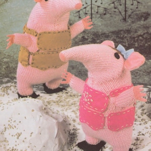 Puede incluir: Dos animales de peluche de punto rosa con hocicos largos y orejas grandes. El juguete de la izquierda lleva un chaleco marrón con botones dorados. El juguete de la derecha lleva un chaleco rosa con costuras blancas y un lazo azul.