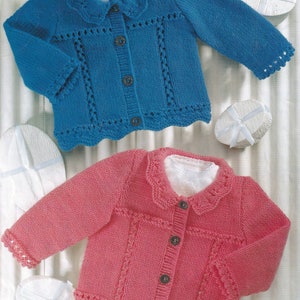 May include: Two knitted baby cardigans, one in blue and the other in pink. Both feature a scalloped collar and hem, decorative openwork panels, and button fastenings. The sleeves and collar are trimmed with a delicate scalloped edge, creating a charming look.