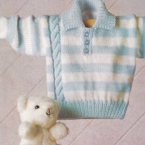 May include: A blue and white striped knitted baby sweater with a cable knit detail on the shoulders and a button-up collar.