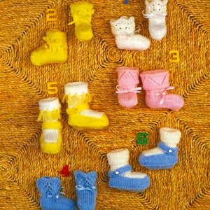 May include: Ten pairs of knitted baby booties in various colours, including yellow, white, pink, and blue. The booties are displayed on a woven straw mat with numbered tags.