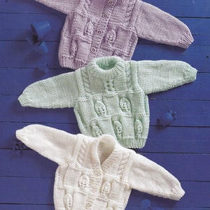 Könnte beinhalten: Drei gestrickte Baby-Cardigans in verschiedenen Farben: Lavendel, Hellgrün und Weiß. Jeder Cardigan hat ein Zopfmuster und einen Knopfverschluss.